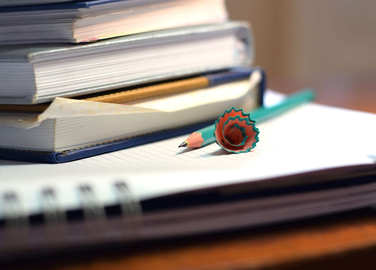 Stacked pads and stationery on a desk